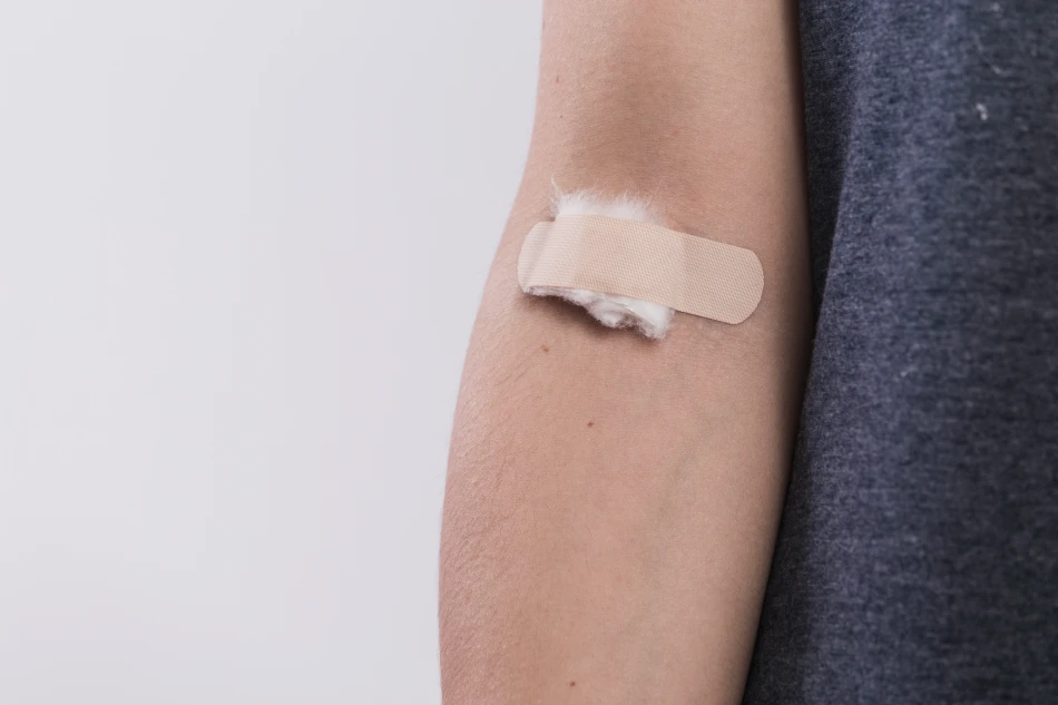 Close up of a woman's hand holding white medical bandage on bleeding wrist